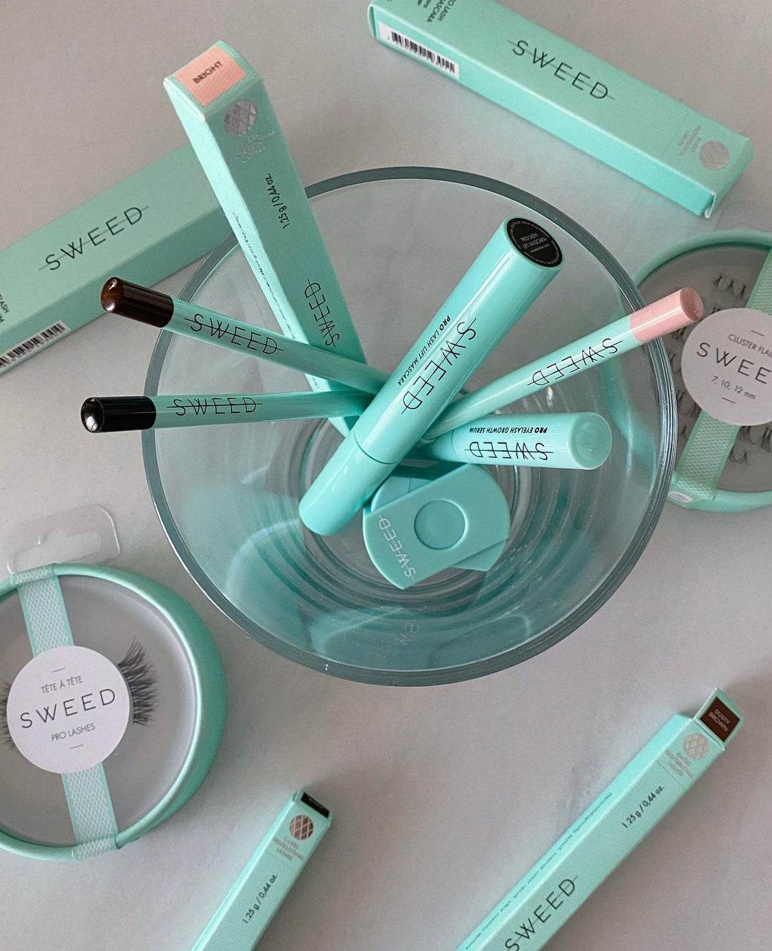 Sweed vegan and cruelty free makeup collection including mascara, eyelash serum, and brushes in turquoise packaging