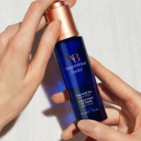 Augustinus Bader The Face Oil in blue bottle with copper cap for radiant and hydrated skin