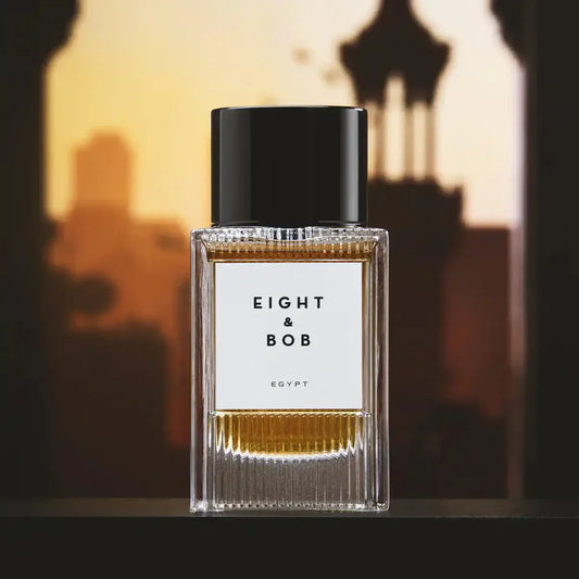 Perfume bottle labeled 'Eight & Bob' with a blurred cityscape background