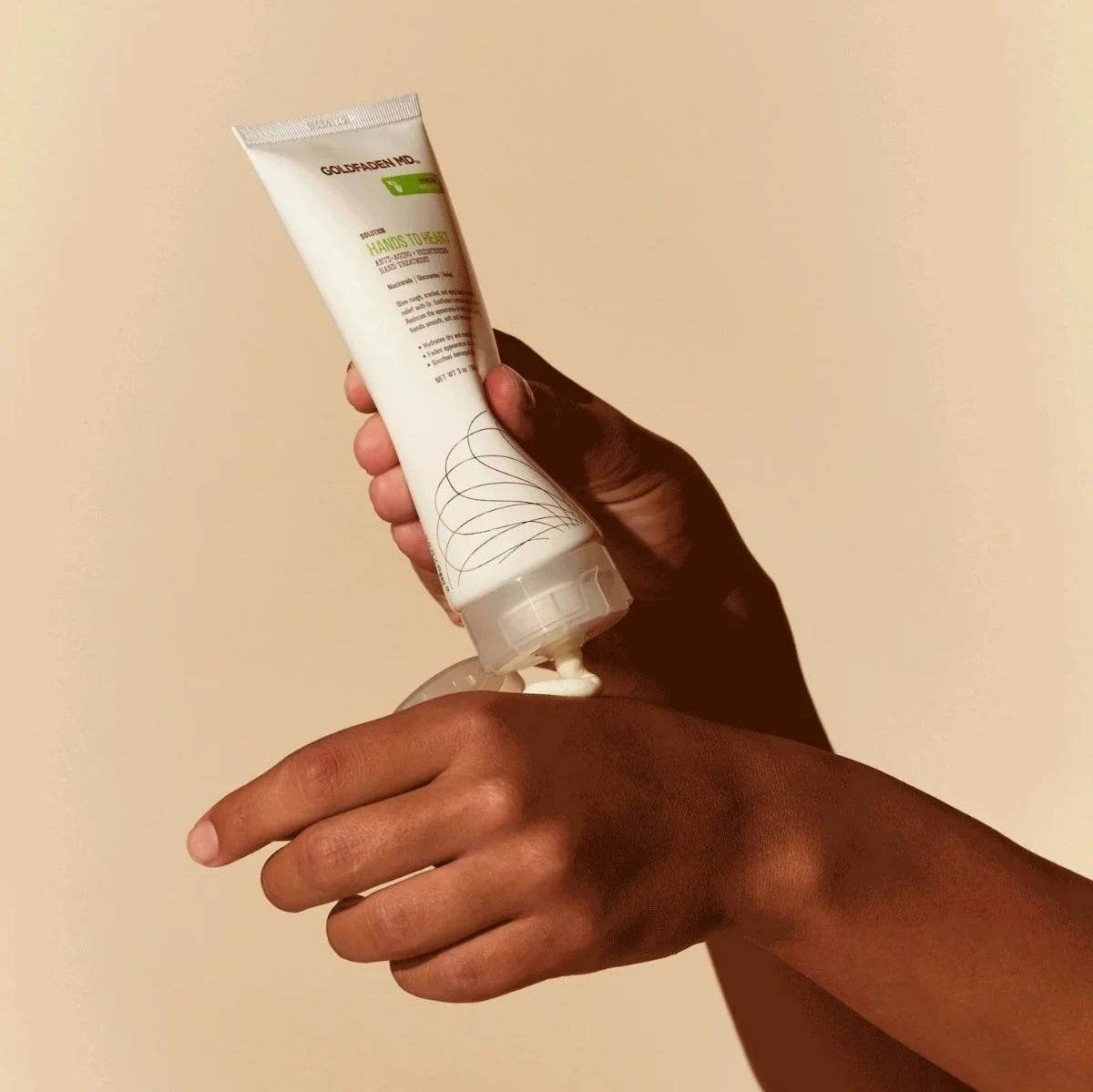 Person applying Goldfaden MD Hands to Heart Brightening Hand Treatment cream on hand