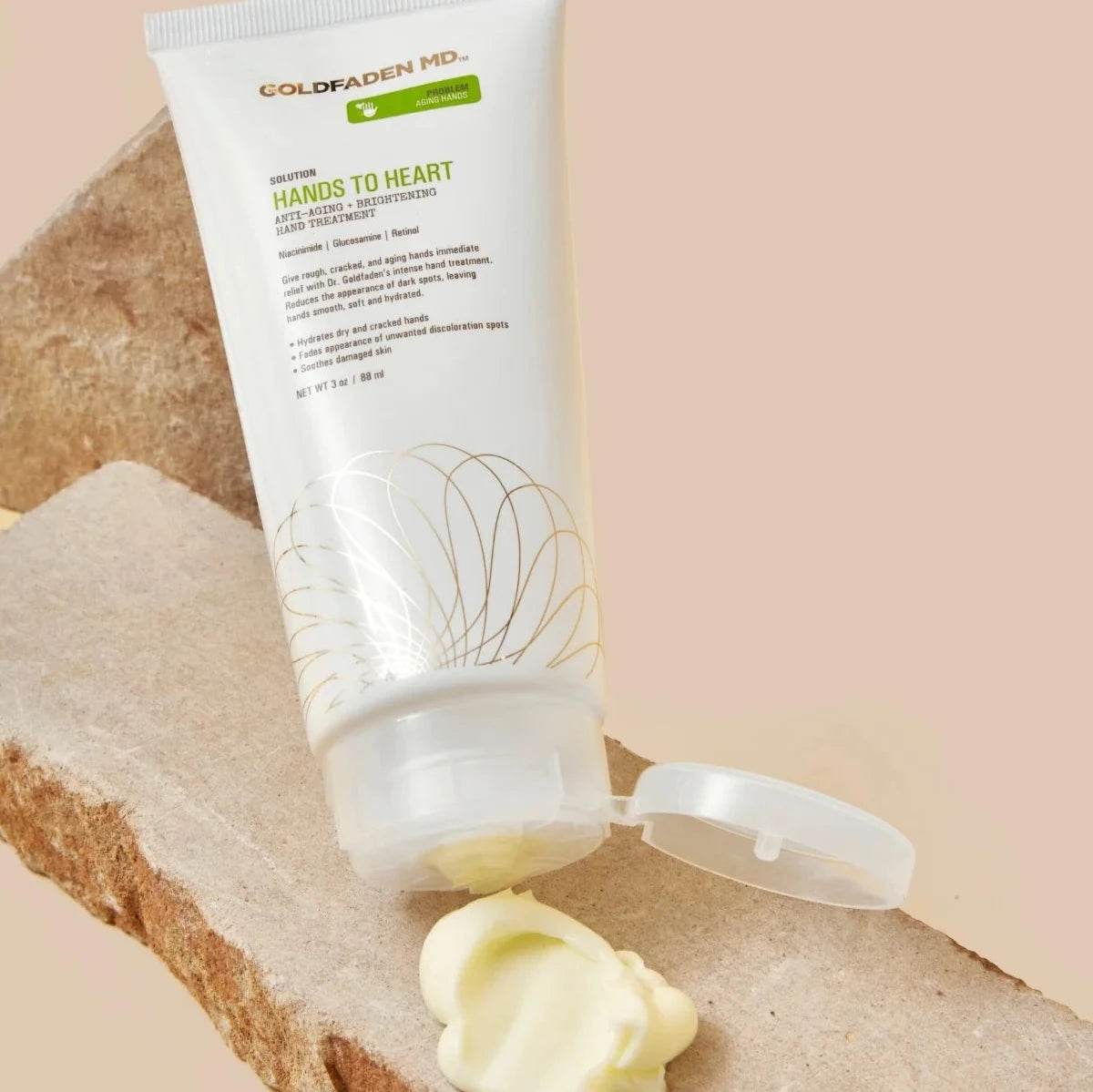 Goldfaden MD Hands to Heart Brightening Hand Treatment tube with cream on stone surface