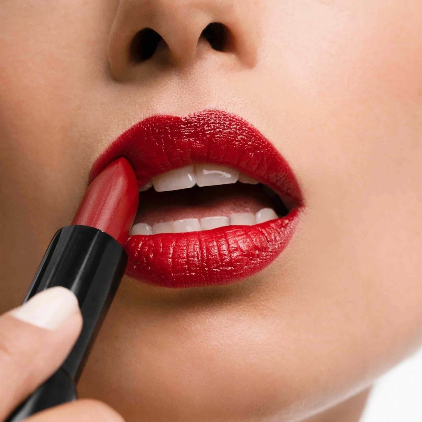 Applying Madame Gabriela Paris At 7pm red lipstick on lips for a bold makeup look