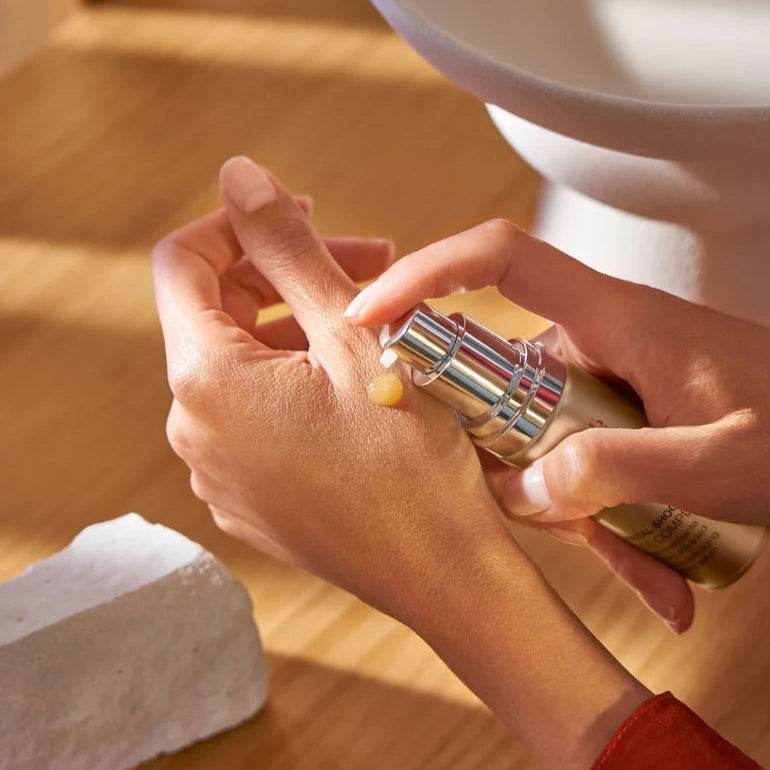 Natura Bissé Anti-Aging Firming Serum being applied to a hand for skin rejuvenation