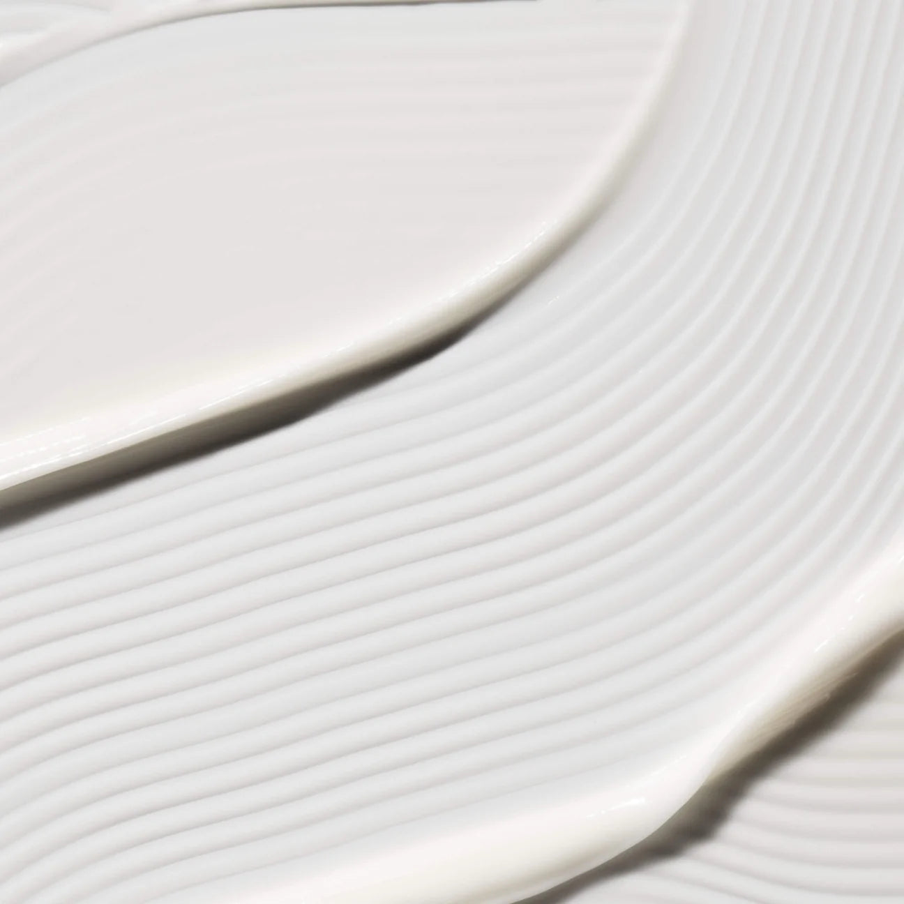 Close-up of creamy white Omorovicza Soothing Salve texture with smooth ridges and gentle swirls