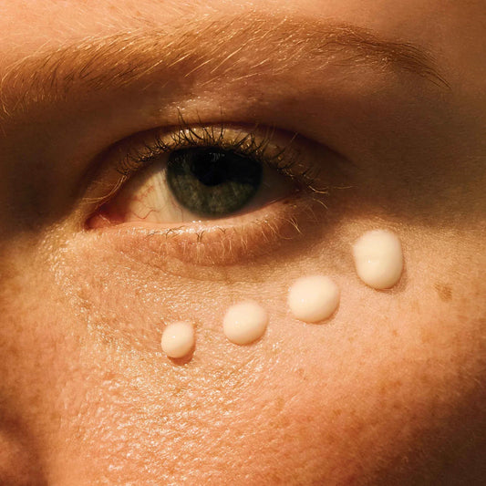 Close-up of Vitamin C eye cream applied under the eye for brightening and hydrating benefits