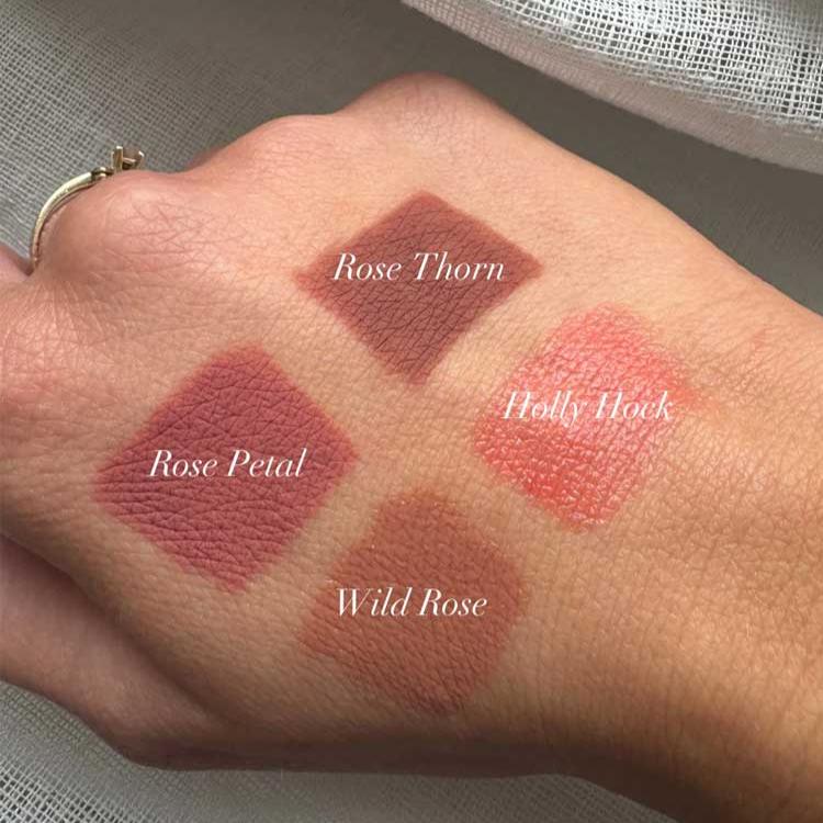 Sweed luxury lip crayon swatches on a hand showing Rose Thorn, Holly Hawk, Rose Petal, and Wild Rose shades