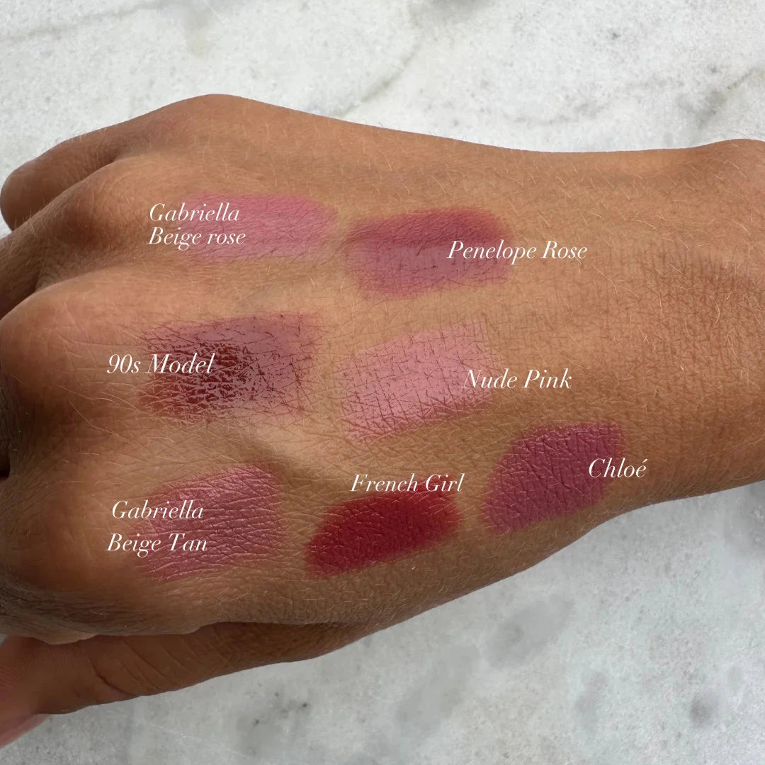 Swatches of Sweed luxury lip crayon shades including Gabriella Beige Rose and Penelope Rose on a hand