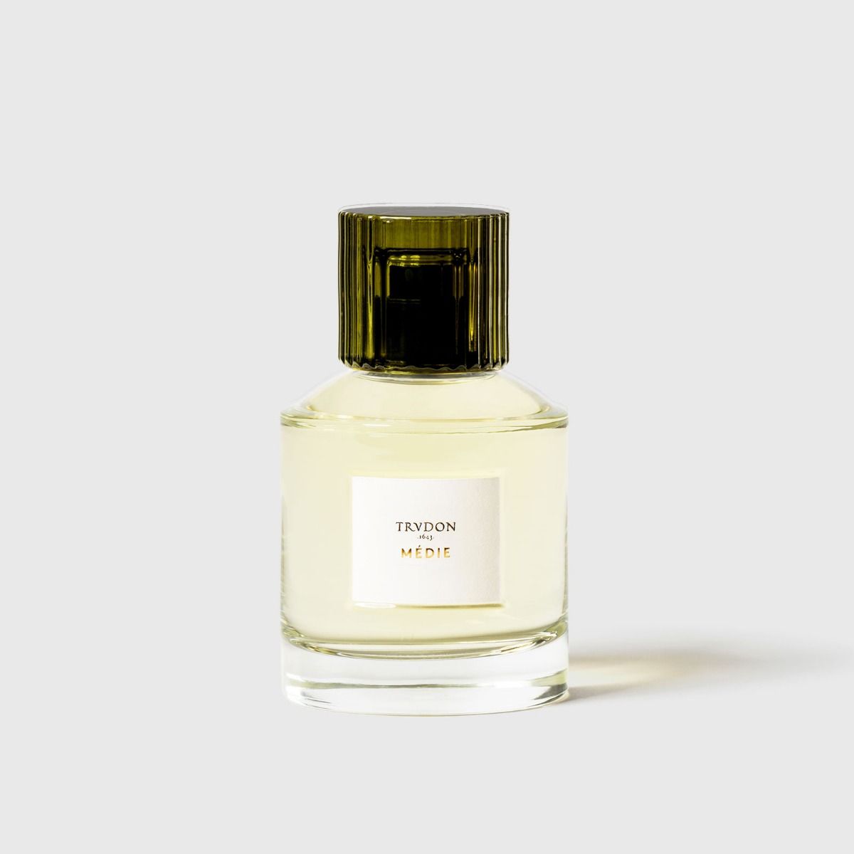 Trudon Médie Eaux De Parfum in a glass bottle with a green cap for luxurious fragrance experiences