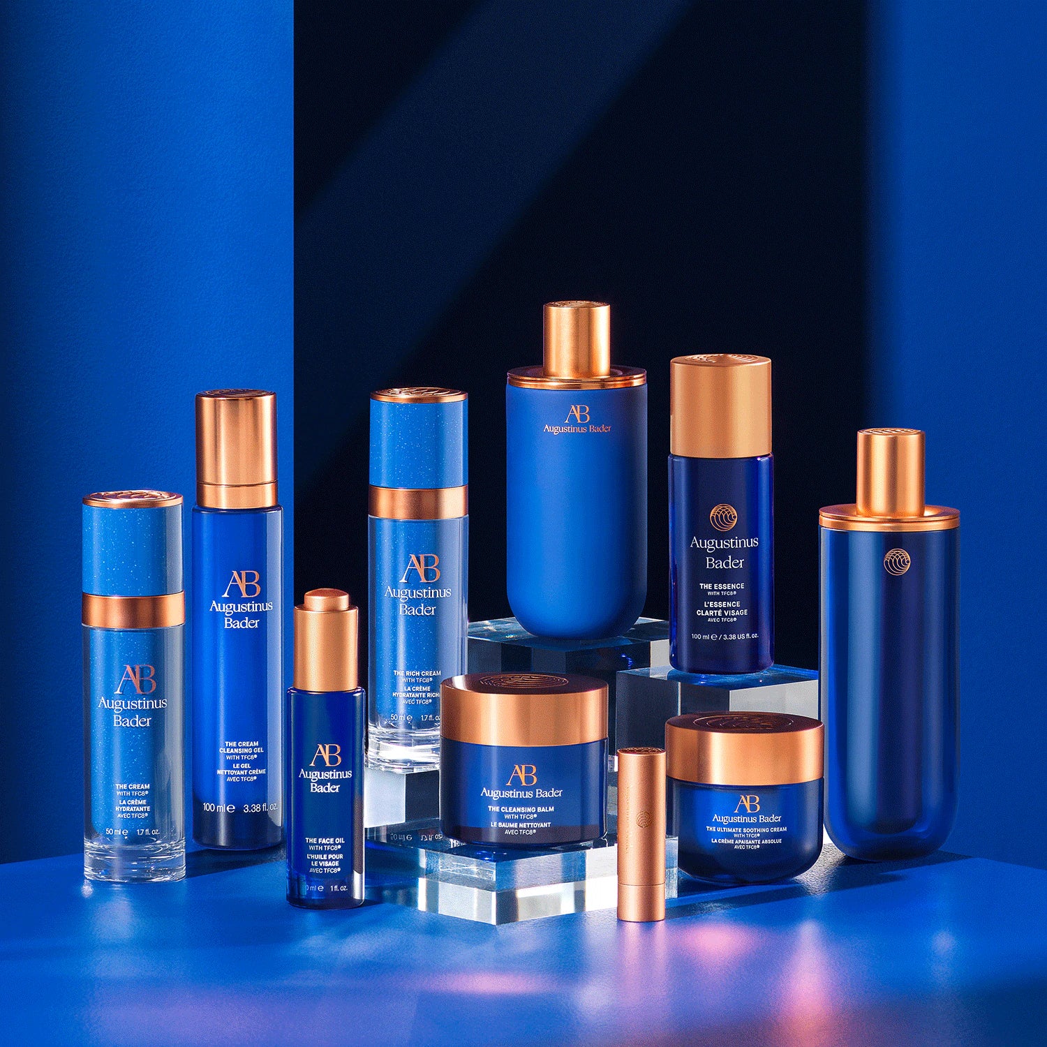 Collection of Augustinus Bader skincare products on a blue background