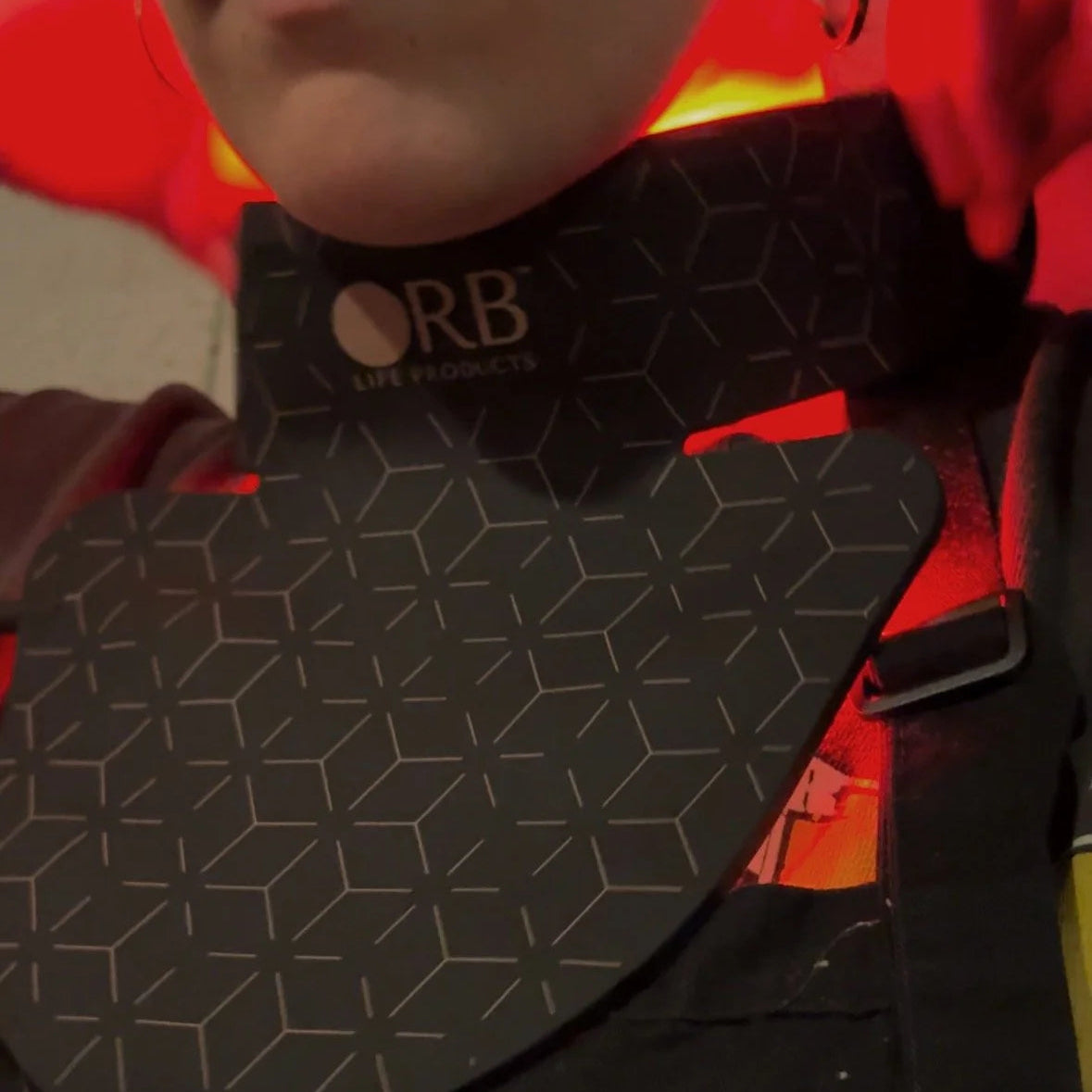 Person wearing a black geometric-patterned product with 'ORB' branding.