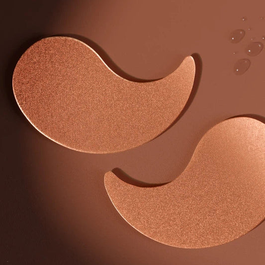 Two bronze-colored eye patches on a brown background