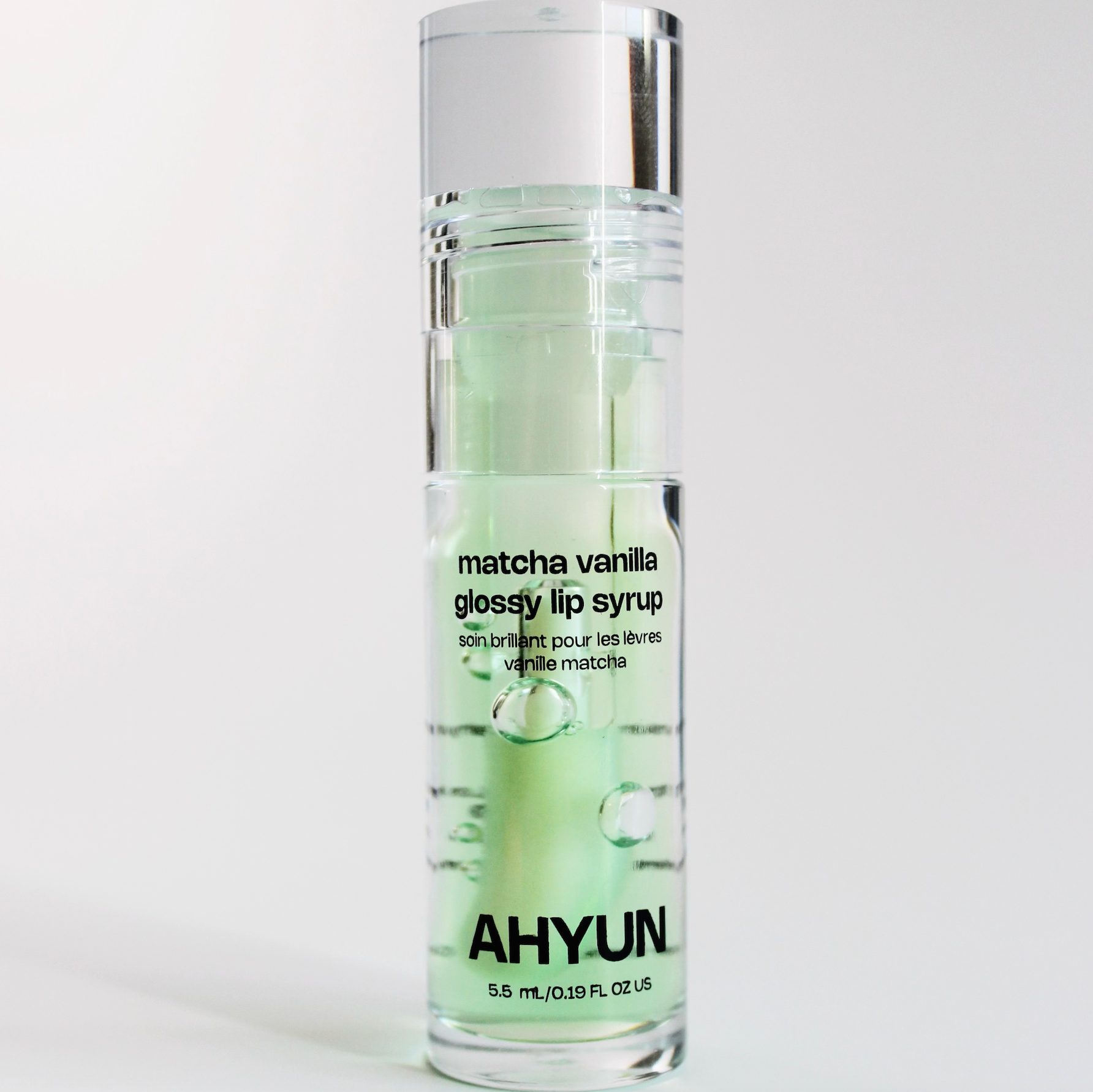 AHYUN matcha vanilla lip gloss in clear pump bottle with mint green serum and silver cap