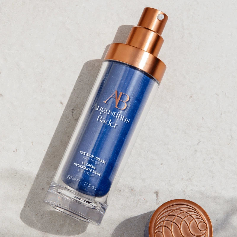 Augustinus Bader The Rich Cream Hydrating Moisturizer in a clear bottle with a copper pump