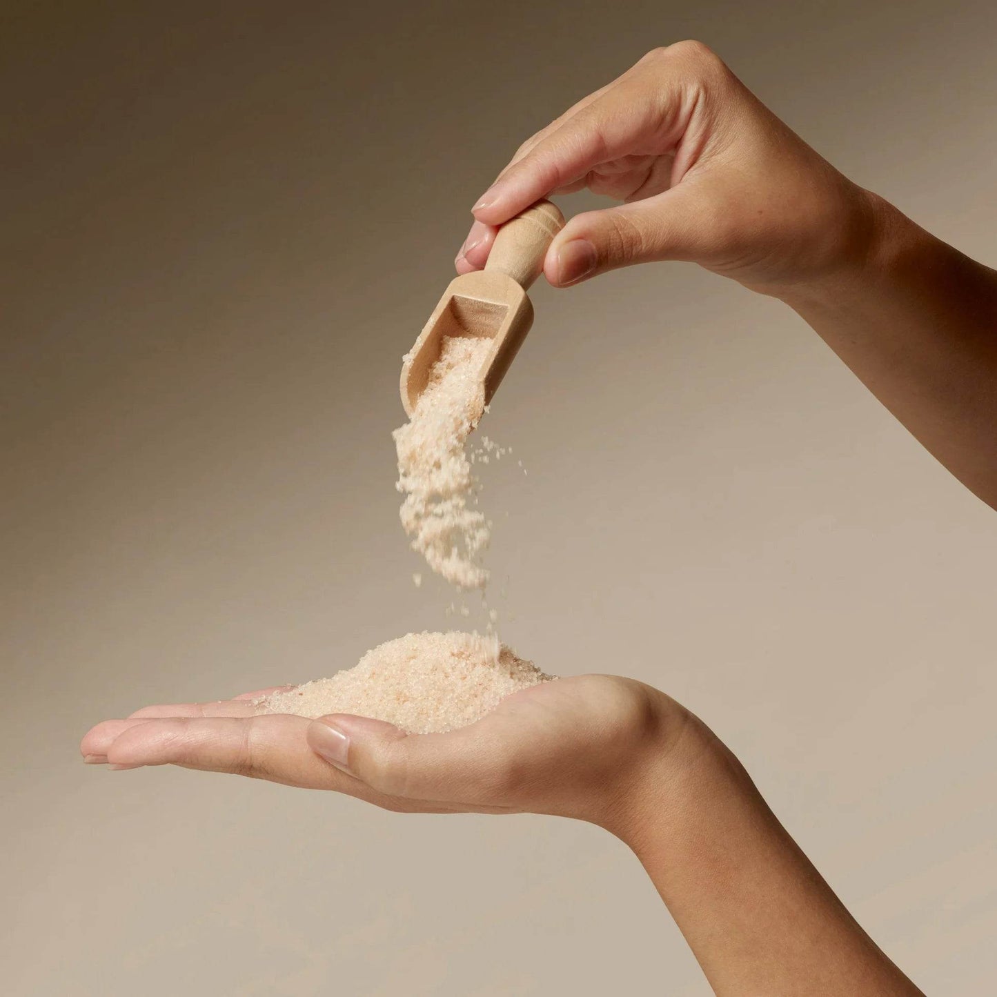 Omorovicza Bath Salts being poured from a wooden scoop into a hand for a relaxing soak