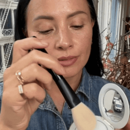 Woman applying Westman Atelier Pressed Powder with a makeup brush for a flawless finish