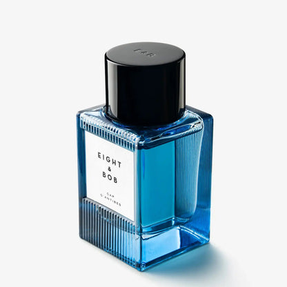 Blue perfume bottle with black cap on a white background