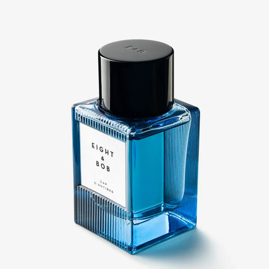 Blue perfume bottle with black cap on a white background