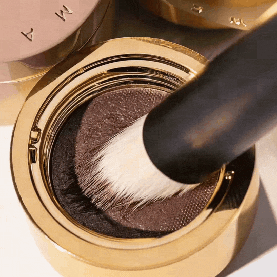 Westman Atelier Eyeshadow II Brush applying rich eyeshadow from a gold compact