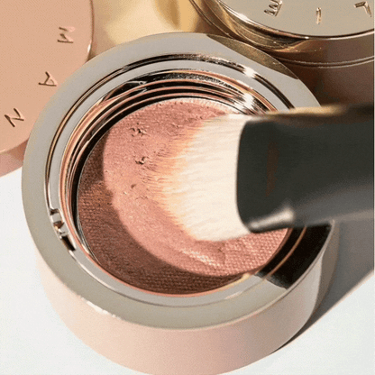 Westman Atelier Eyeshadow l Brush applying soft pink eyeshadow in a sleek compact
