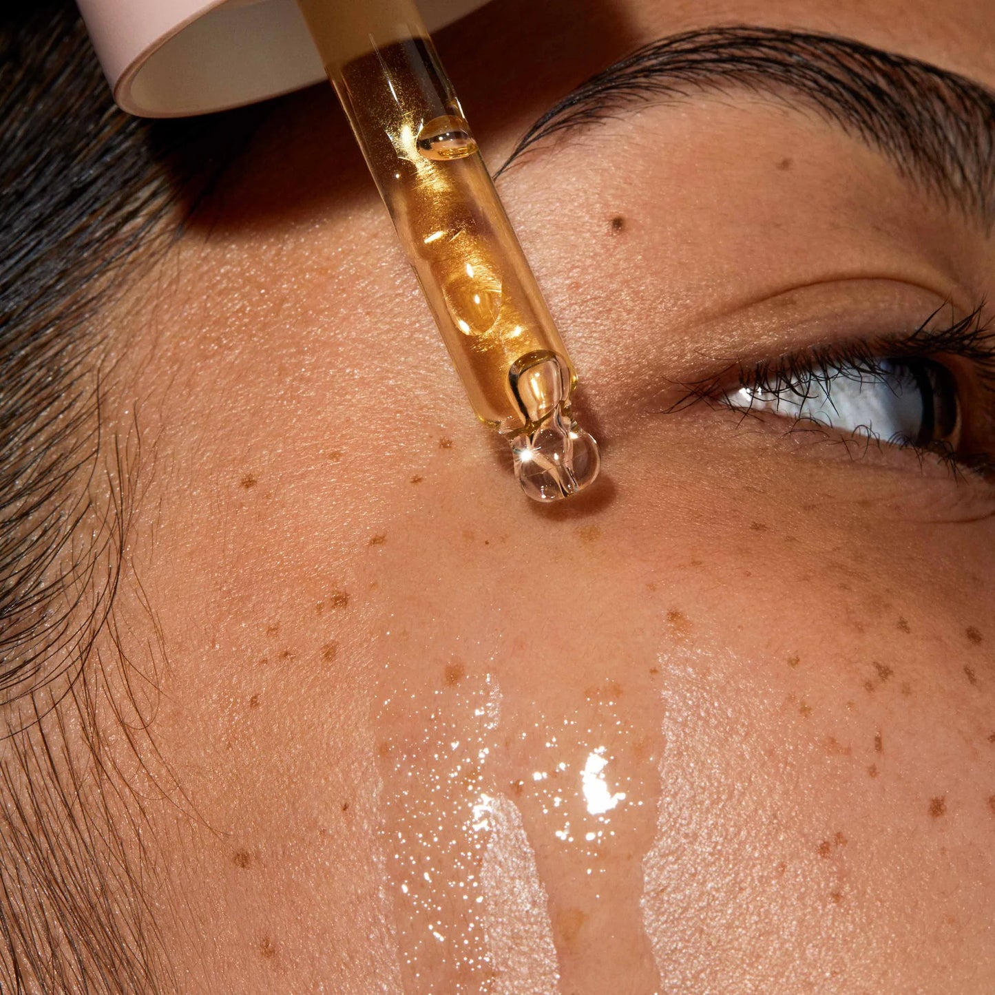 Omorovicza Facial Oil dripping onto skin, showcasing a hydrating and nourishing formula