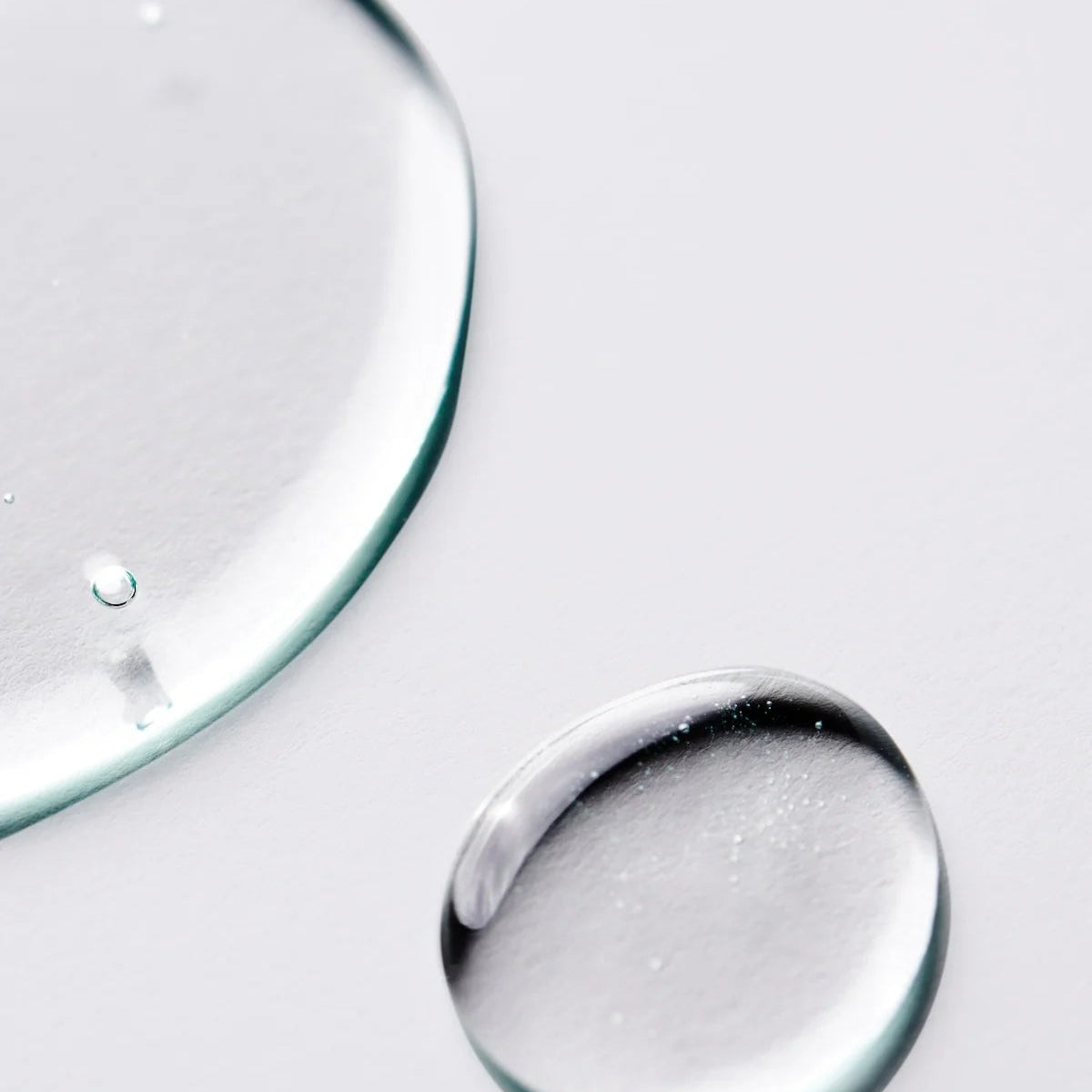 Close-up of clear serum drops representing Goldfaden MD Brightening Elixir Hydrating Brightening Serum