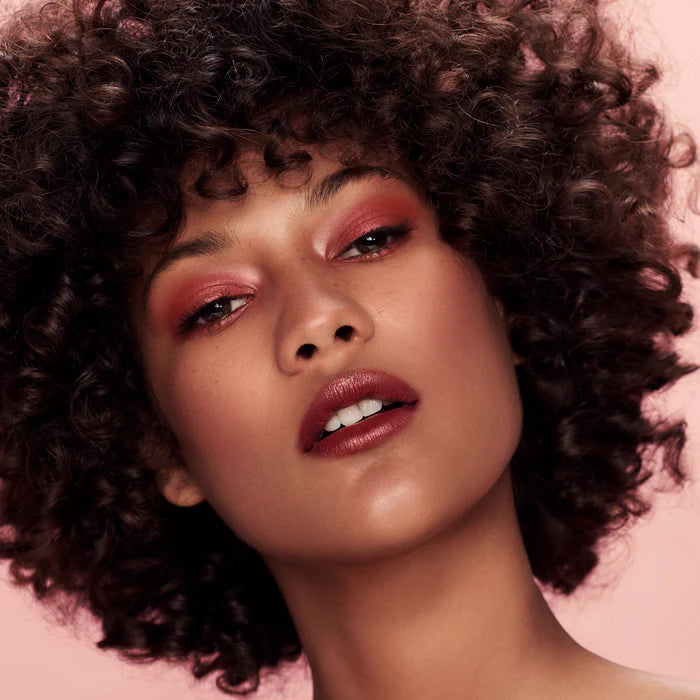 Rituel de Fille Lipstick on model with curly hair showcasing a natural beauty look