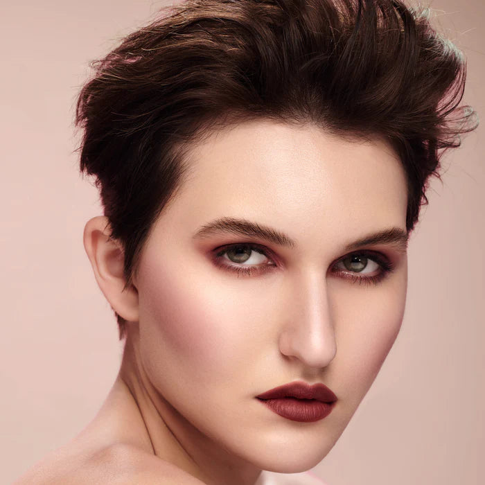 Rituel de Fille Lipstick in a rich shade, displayed on a model with short hair and elegant makeup