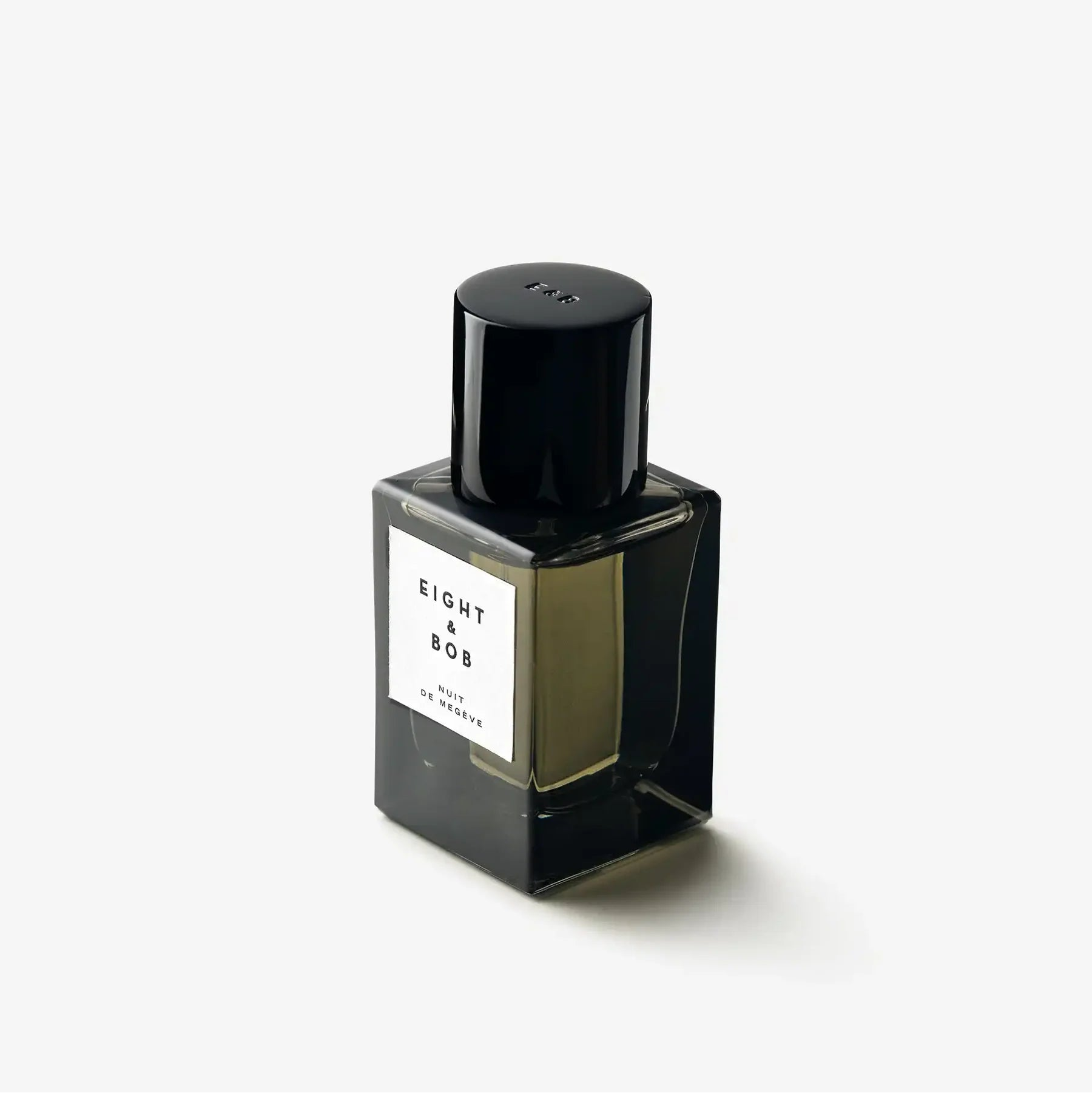 Black perfume bottle with a white label on a white background