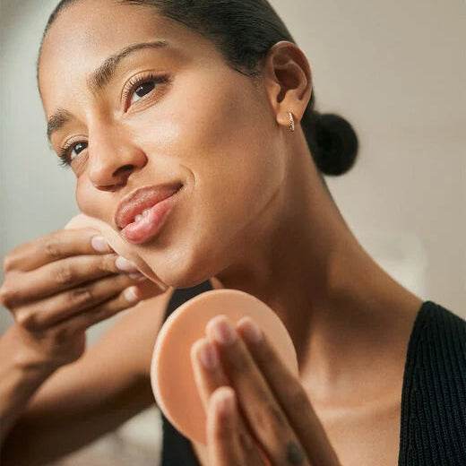Woman using Natura Bissé best facial cleansing sponges for a gentle skincare routine