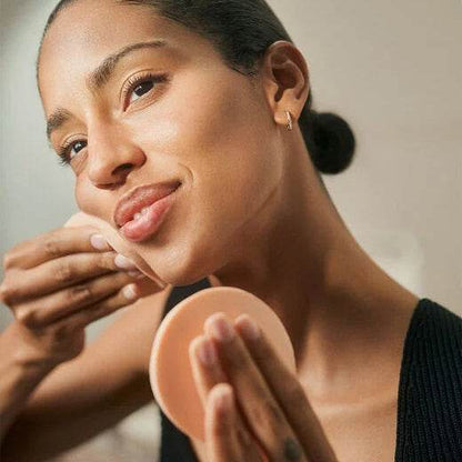 Woman using Natura Bissé best facial cleansing sponges for a gentle skincare routine