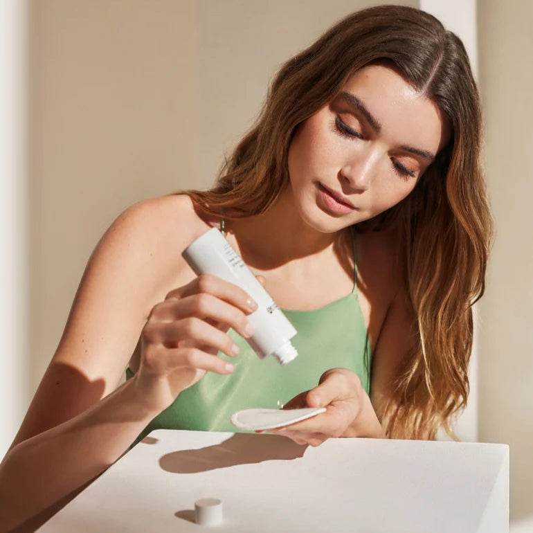 Natura Bissé Daily Exfoliant Solution being applied with a cotton pad for radiant skin