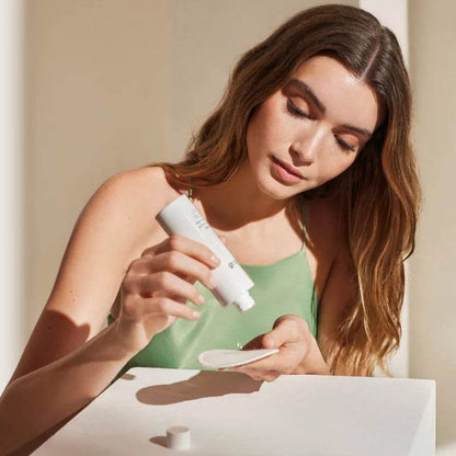 Natura Bissé Daily Exfoliant Solution being applied with a cotton pad for radiant skin