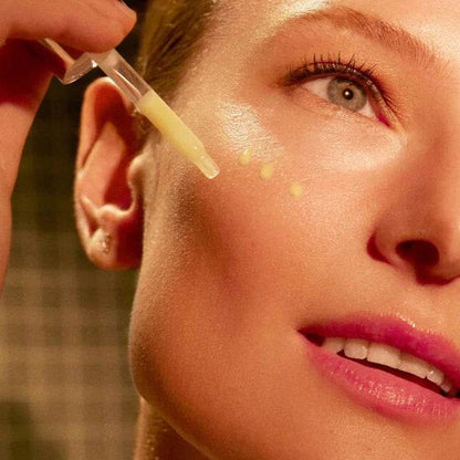 Woman applying Natura Bissé Firming And Resurfacing Serum on her cheek for smooth skin