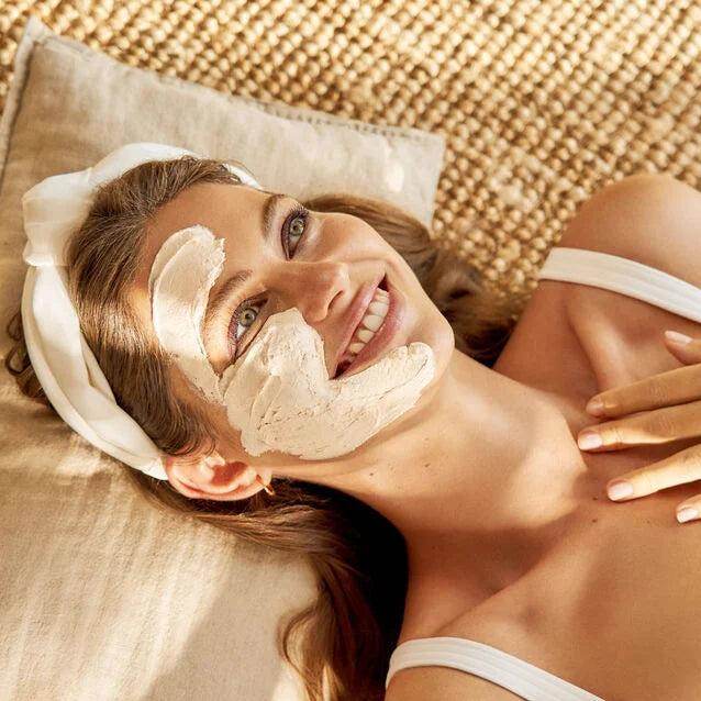 Woman relaxing with Natura Bissé Firming Antioxidant Mask applied on her face for skincare benefits