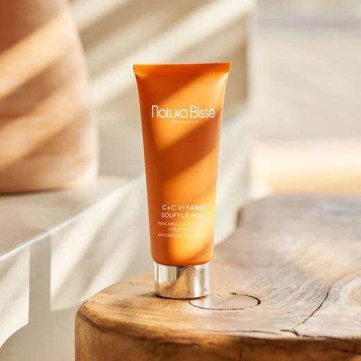Natura Bissé Firming Antioxidant Mask in a vibrant orange tube on a wooden table