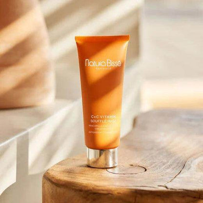 Natura Bissé Firming Antioxidant Mask in a vibrant orange tube on a wooden table