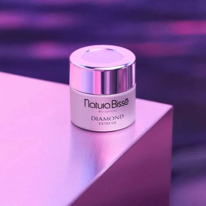 Natura Bisse Diamond Extreme Rejuvenating Moisturizer in a sleek container on a reflective surface