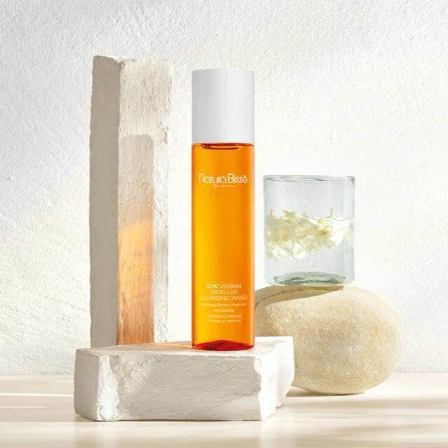 Natura Bisse Revitalizing cleanser and makeup remover in a glass bottle on a stylish display