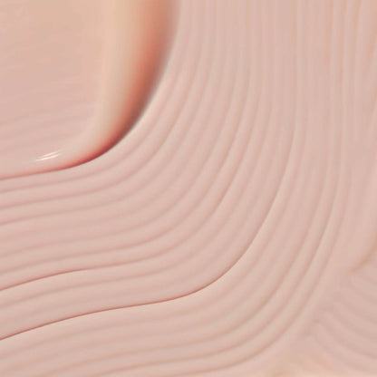 Close-up of a creamy texture showcasing Omorovicza retinol alternative serum in soft pink hue