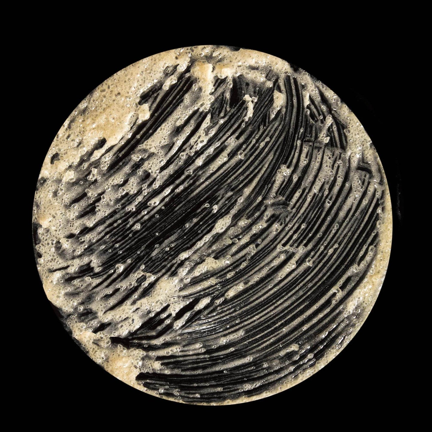 Omorovicza Sugar Scrub in a circular container with a textured black and brown surface