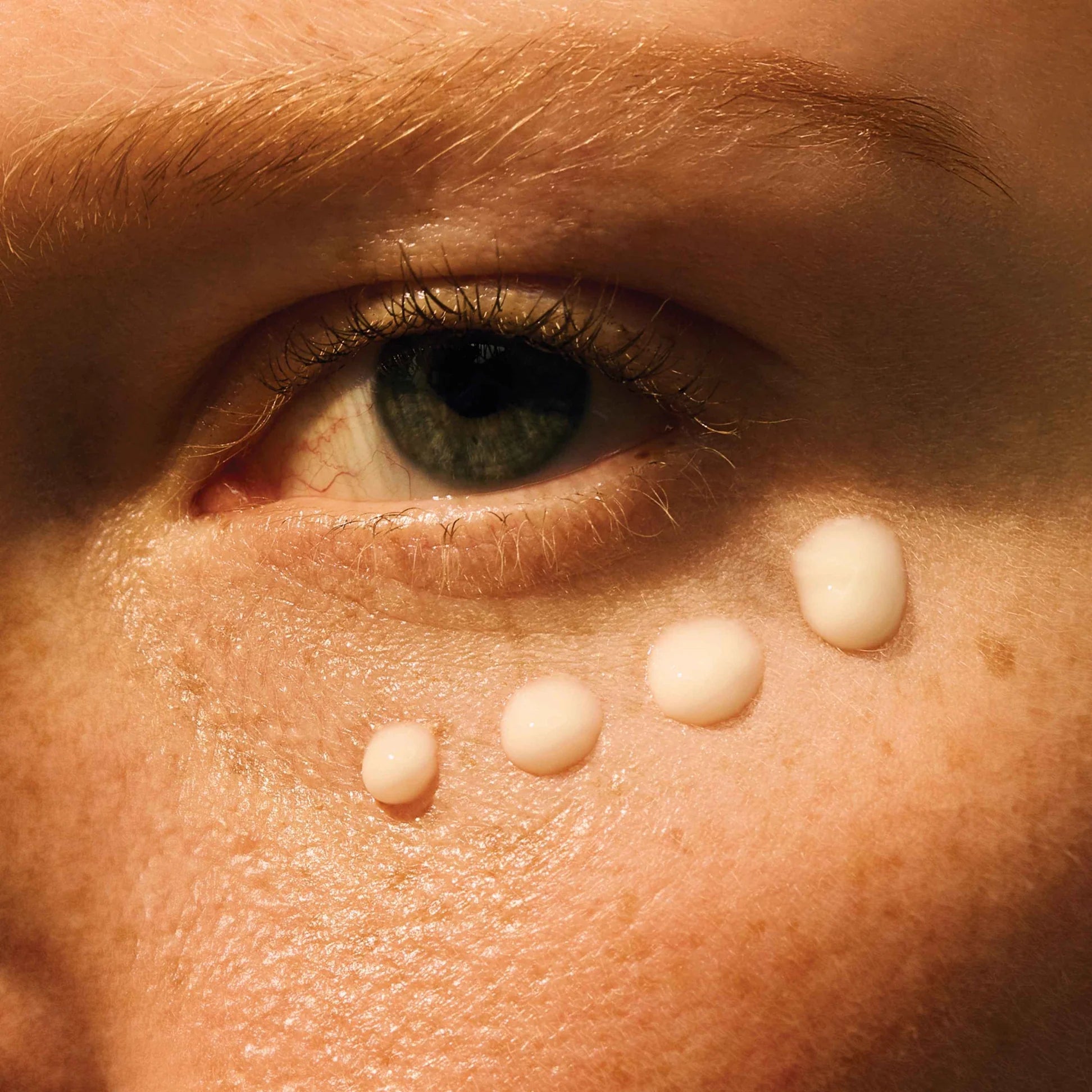 Close-up of Vitamin C eye cream applied under the eye for brightening and hydrating benefits