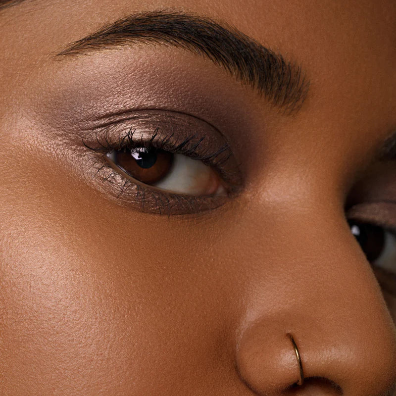 Close-up of an eye showcasing a shimmering application of Cream Eyeshadow by Rituel de Fille