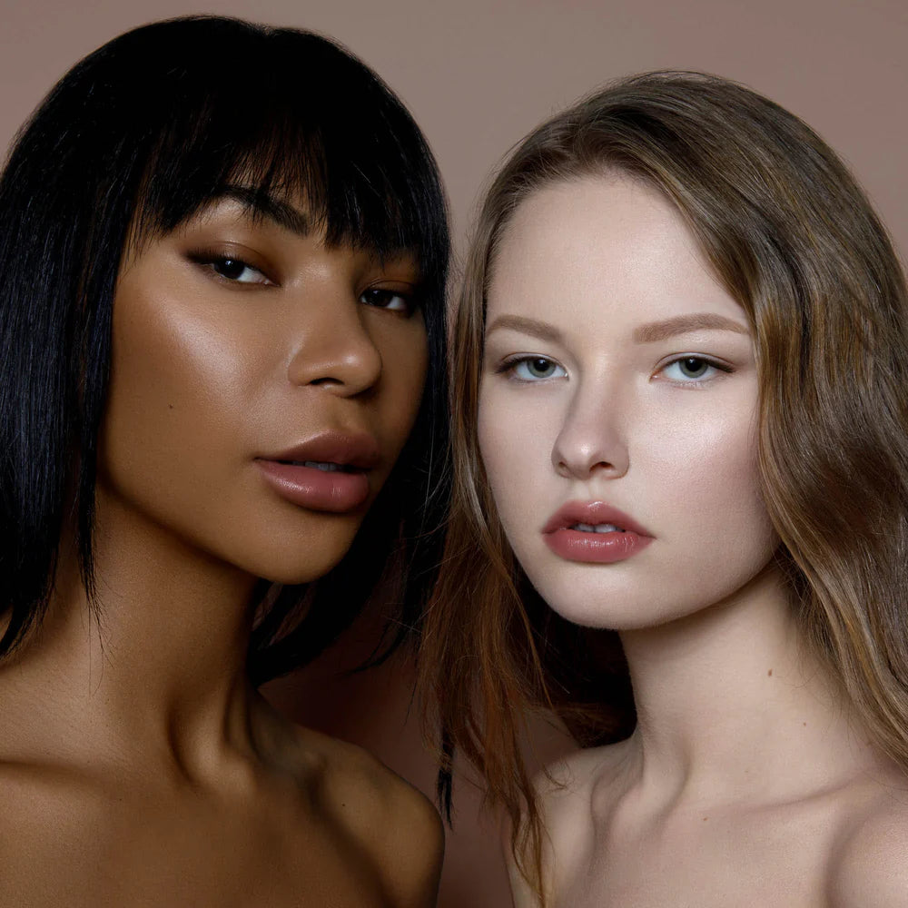 Rituel de Fille Lip Oil applied on lips of two models showcasing a glossy finish