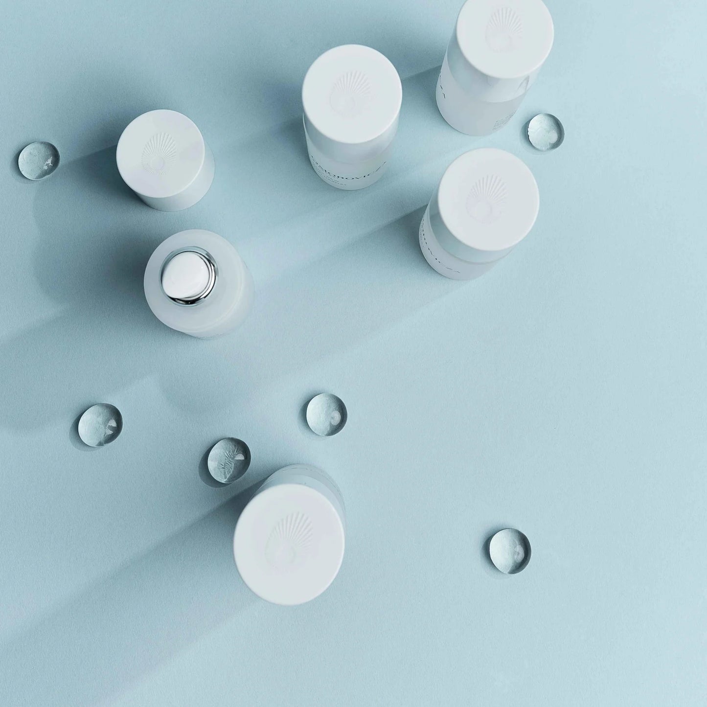 Omorovicza Gel Moisturizer bottles arranged on a blue background with water droplets