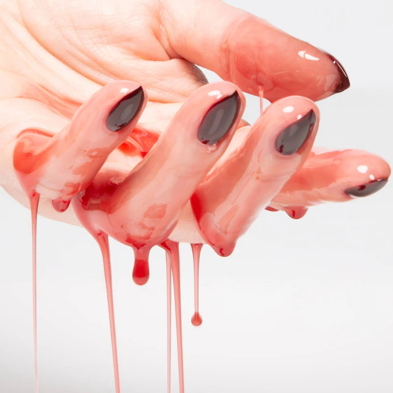Rituel de Fille Priming Facial Elixir dripping from a hand with bold nails for radiant skin