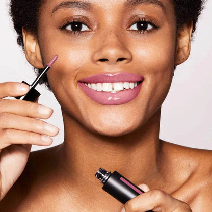 Westman Atelier Tinted Lip Balm applied by a smiling model, showcasing a soft pink hue on lips