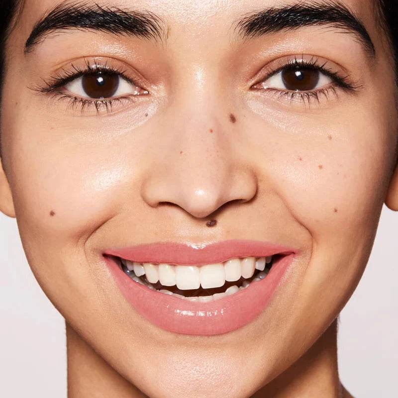 Model showcasing natural glow with Westman Atelier Tinted Lip Balm in a soft shade on lips