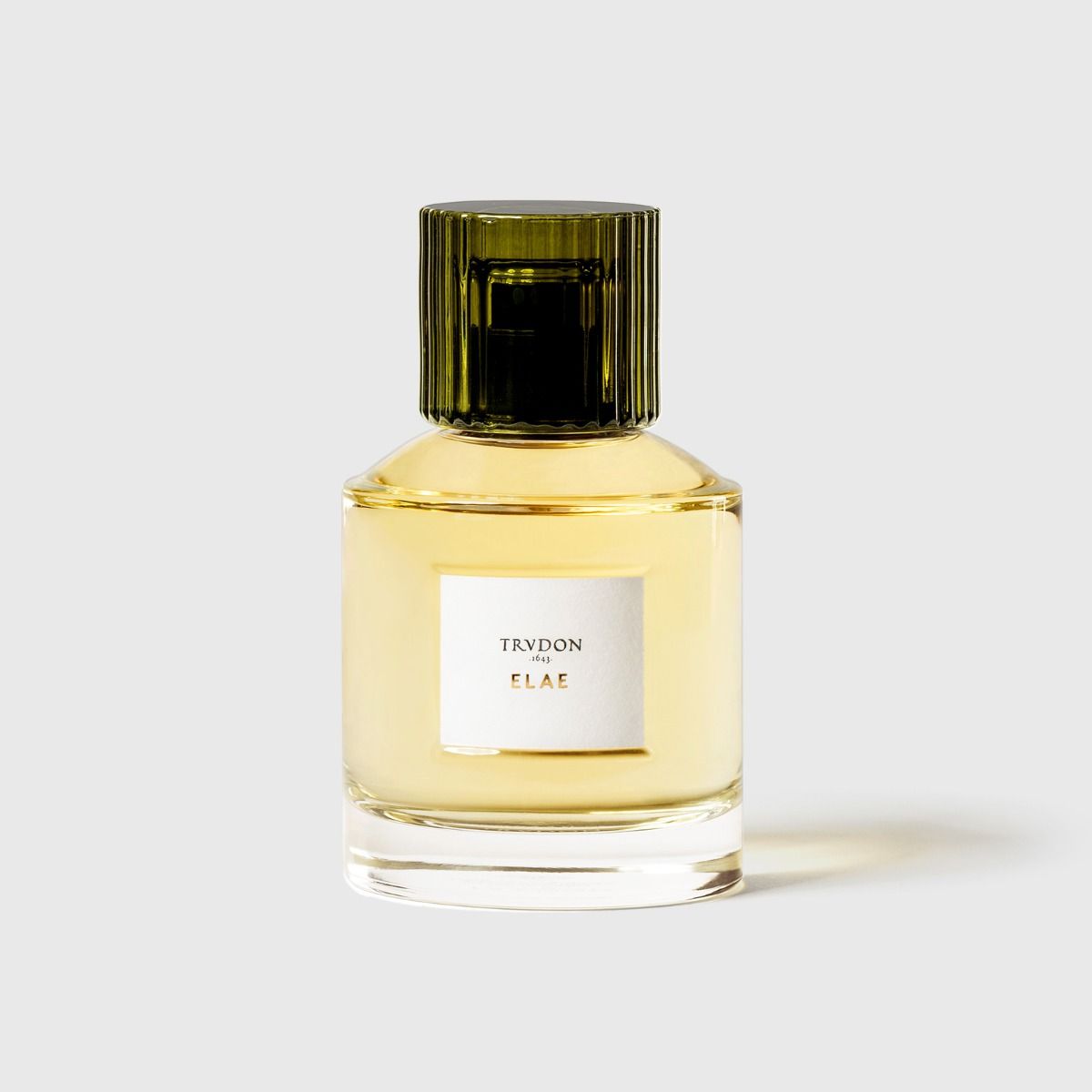 Trudon Elae Eaux De Parfum in a clear glass bottle with green cap, showcasing elegant fragrance.