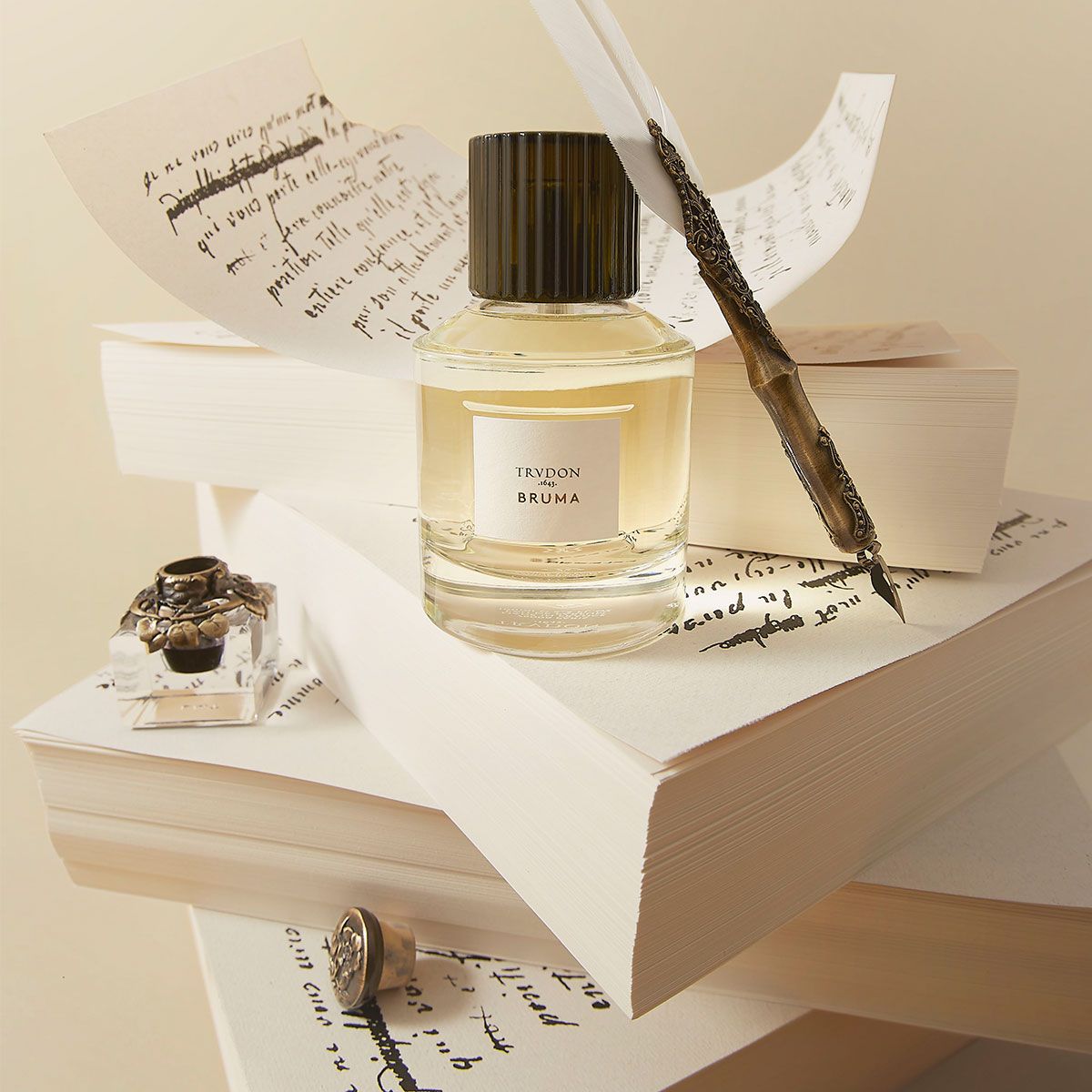 Trudon Bruma Eaux De Parfum bottle on vintage paper with a quill and ink