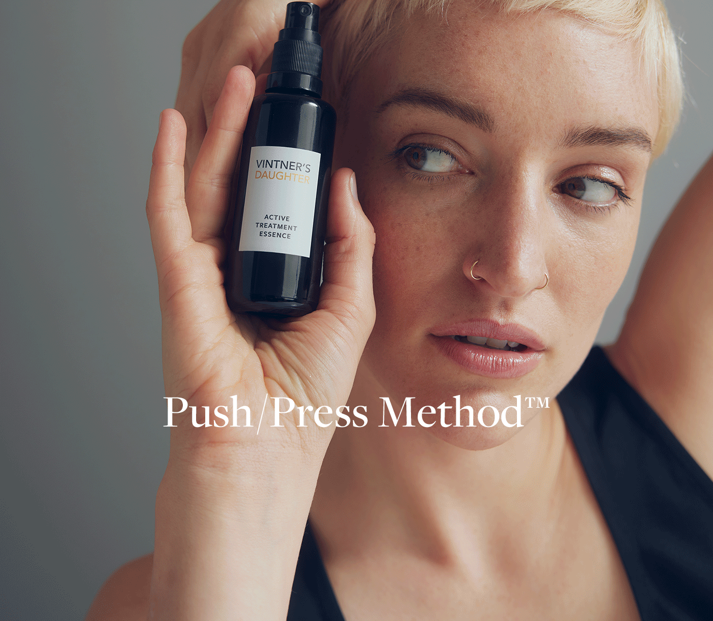 Vintner's Daughter skincare bottle held by woman demonstrating Illuminating and Renewing Hydration Push Press Method